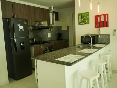 a kitchen with a black refrigerator and some bar stools at Morros 3 in Cartagena de Indias