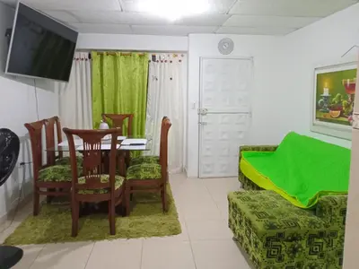 a living room with a table and chairs and a television at Rosymar in Cartagena de Indias