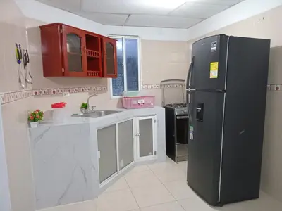 a kitchen with a black refrigerator and red cabinets at Rosymar in Cartagena de Indias
