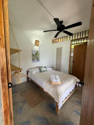 a bedroom with a bed with a ceiling fan at Cabaña Punta Coral in Rincón
