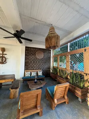 a living room with wooden furniture and a ceiling fan at Cabaña Punta Coral in Rincón