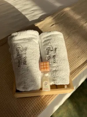 a tray with towels and a bottle of soap on a bed at Cabaña Punta Coral in Rincón