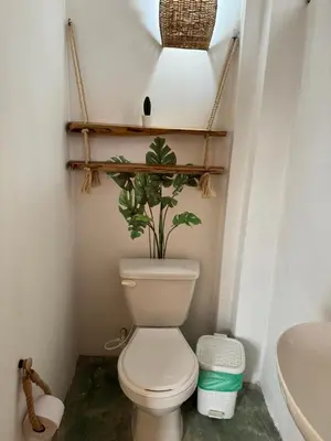 a bathroom with a toilet with a plant on top at Cabaña Punta Coral in Rincón