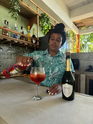 a man sitting at a table with a bottle of wine at Cabaña Punta Coral in Rincón