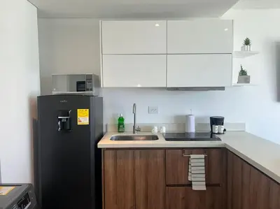 a kitchen with a black refrigerator and a sink at Apartamento Duplex en Barranquilla in Barranquilla