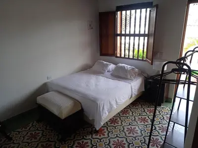 a small bedroom with a bed and a window at Casa Belia in Cartagena de Indias