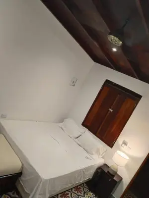 a small room with a bed and a cabinet at Casa Belia in Cartagena de Indias