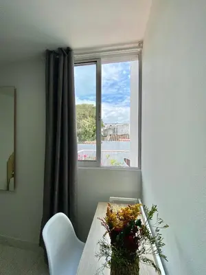 a table with a vase of flowers and a window at Casa Jardin in Cartagena de Indias