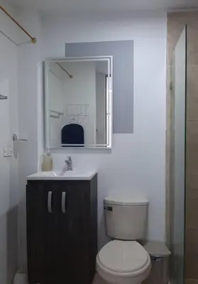 a bathroom with a toilet and a sink and a mirror at Apartamento familiar en Coveñas in Coveñas