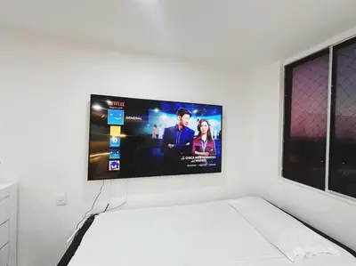 a flat screen tv hanging on a white wall at Apto nuevo al lado de la UNorte, 10 Min Buena vista Grav vista in Barranquilla