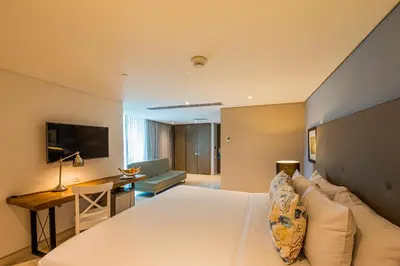 a hotel room with a large bed and a desk at GHL San Lazaro Art Hotel in Cartagena de Indias