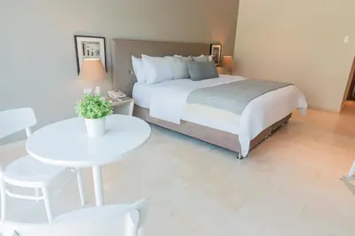 a bedroom with a bed and a table and chairs at GHL San Lazaro Art Hotel in Cartagena de Indias