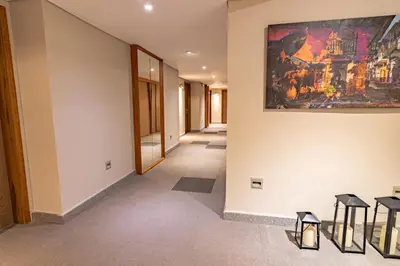 a hallway with a painting on the wall and stools at GHL San Lazaro Art Hotel in Cartagena de Indias