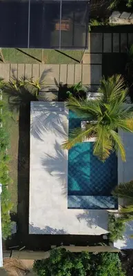a swimming pool with a palm tree next to a house at Mykonos Beach House Apartamentos By Jerusalema in Tolú