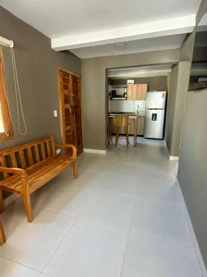 a living room with a bench and a kitchen at Mykonos Beach House Apartamentos By Jerusalema in Tolú