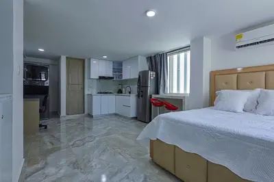 a large bedroom with a bed and a kitchen at Lujoso Apartamento con salida a la playa in Cartagena de Indias