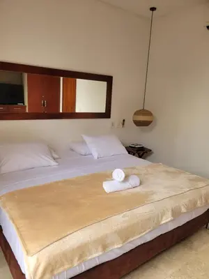 a bedroom with a bed with two towels on it at Apartamentos 129 Casa del Virrey Eslava Centro Histórico in Cartagena de Indias