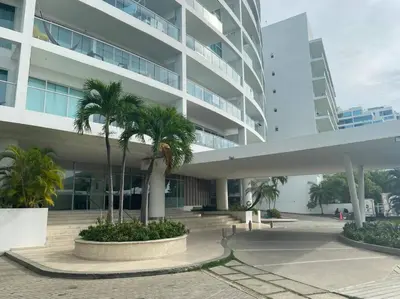 a large building with palm trees in front of it at Cartagena Apartamento en Morros en Primera Linea de PLaya in Cartagena de Indias
