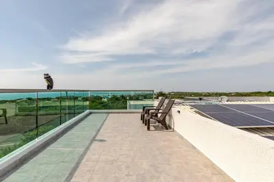 a balcony with two chairs and a solar panel at Studio at the Resort Residence 2 in Puerto Colombia