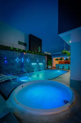 a large bath tub in the middle of a pool at night at Studio at the Resort Residence 2 in Puerto Colombia