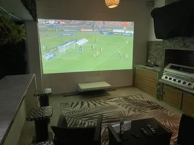 a room with a large screen showing a soccer game at Studio at the Resort Residence 2 in Puerto Colombia