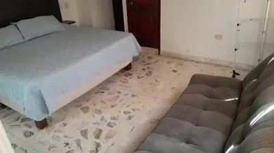 a bedroom with a bed and a couch and a floor at Hotel Boutique - Casa Completa en Cartagena de Indias, barrio Castillogrande in Cartagena de Indias