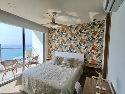 a bedroom with a bed and a view of the ocean at Great sunsets & sea views, near beach&downtown in Cartagena de Indias