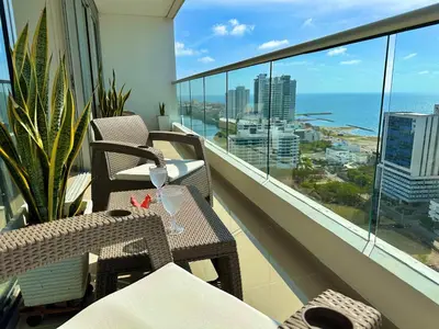 a balcony with chairs and tables and a view of the ocean at Great sunsets & sea views, near beach&downtown in Cartagena de Indias