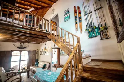 a room with a wooden staircase with a table and skis on the wall at ACUARELA in Trementino