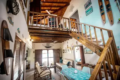 a living room with a wooden staircase and a living room with chairs at ACUARELA in Trementino