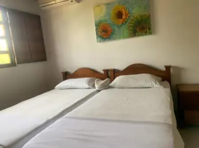 a bed in a bedroom with a flower painting on the wall at ACUARELA in Trementino