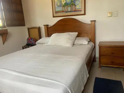a bedroom with a large white bed and a dresser at ACUARELA in Trementino
