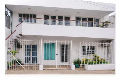 a white building with a gate in front of it at Maos flats-Habitacion comfort in Cartagena de Indias