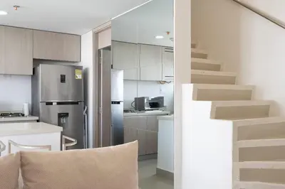 a kitchen with a stainless steel refrigerator and stairs at Luxury Apartment In Bocagrande With Ocean View 502 in Cartagena de Indias