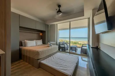 a bedroom with a bed and a view of the ocean at Cartagena Beach Resort in Cartagena de Indias