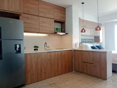 a kitchen with wooden cabinets and a refrigerator at Cartagena Beach Resort in Cartagena de Indias
