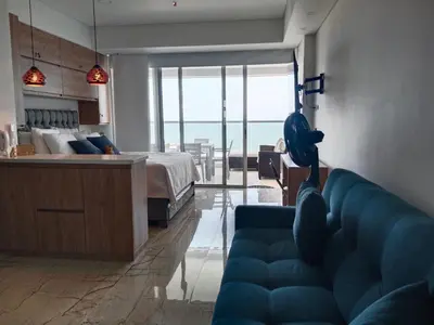 a living room with a blue couch and a bedroom at Cartagena Beach Resort in Cartagena de Indias