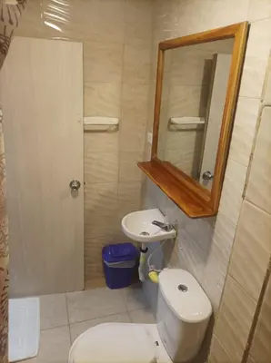 a bathroom with a toilet and a sink and a mirror at Hostal Catalleya in Cartagena de Indias