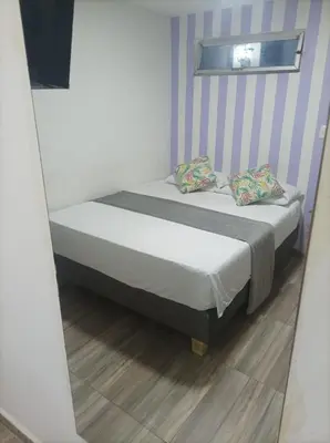 a bed in a room with a mirror at Hostal Catalleya in Cartagena de Indias