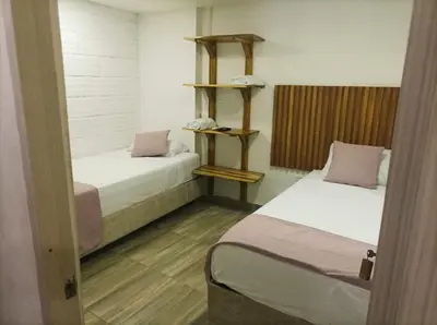 two beds in a small room with two beds sidx sidx sidx at Hostal Catalleya in Cartagena de Indias
