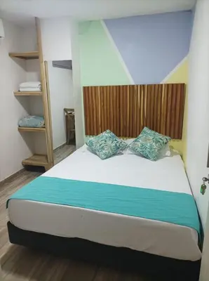a bedroom with a bed with a bow tie on it at Hostal Catalleya in Cartagena de Indias