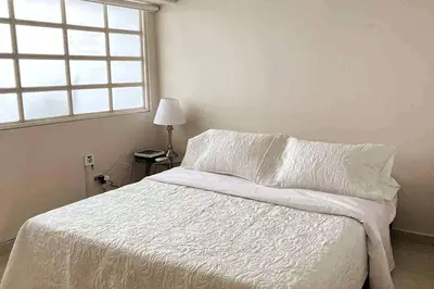 a white bed in a bedroom with a window at Vacation Home Apartment in Cartagena in Cartagena de Indias