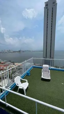 a balcony of a building with two chairs and the water at Vacation Home Apartment in Cartagena in Cartagena de Indias