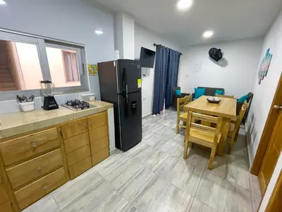 a kitchen with a black refrigerator and a table at Apartamento Villa Carolina 102 in Coveñas