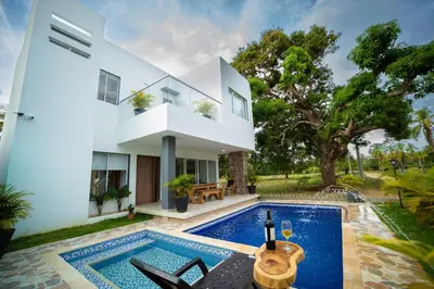 a villa with a swimming pool and a house at Cabaña Villa July in Moñitos