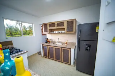 a kitchen with a black refrigerator and a sink at Cabaña Villa July in Moñitos