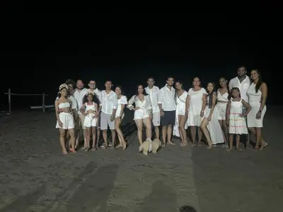 a group of people standing on the beach at night at Cabaña Villa July in Moñitos