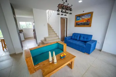 a living room with a blue couch and a table at Cabaña Villa July in Moñitos