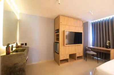 a hotel room with a bed and a tv and a desk at Mood Matuna Hotel Cartagena in Cartagena de Indias