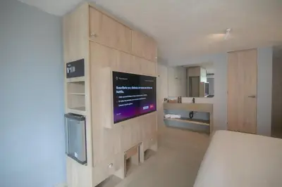 a bedroom with a tv on a wooden wall at Mood Matuna Hotel Cartagena in Cartagena de Indias